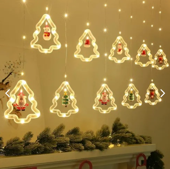Luces cálidas en cascada con figuras de árboles y personajes navideños sobre una chimenea
